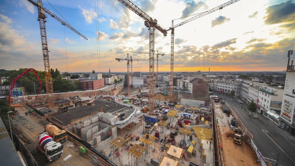 construction monitoring, top view of the construction site with cranes and the city in the background