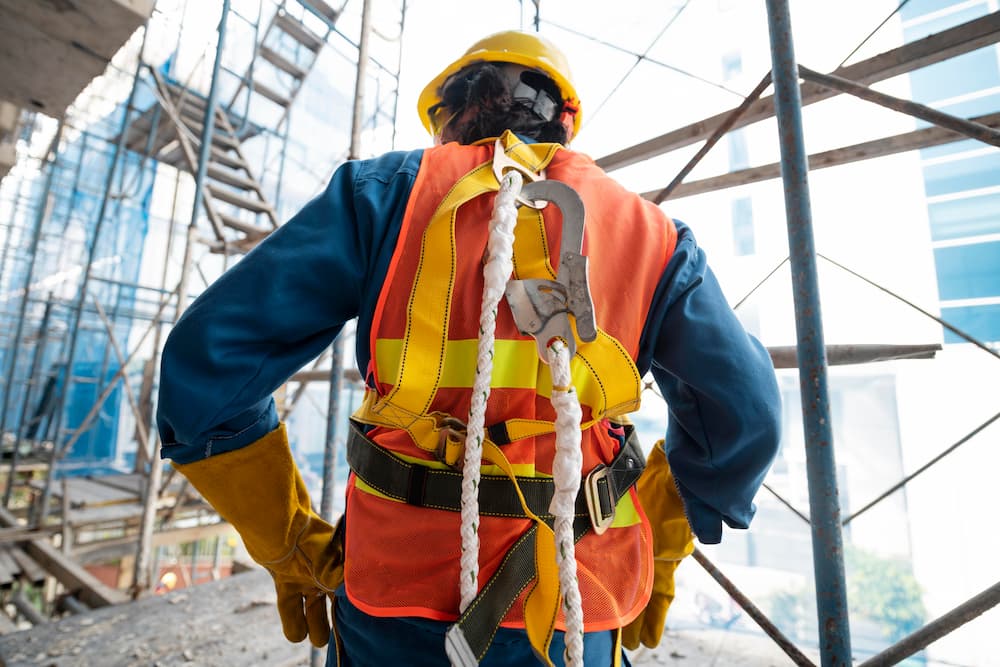 construction site safety equipment: worker wearing fall equipment 