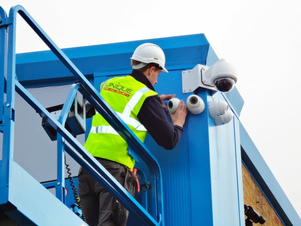 worker checking a videosurveillance camera in a construction site